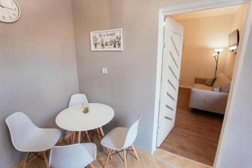 a small white table and chairs in a room at Maniu 31 Apartments & Rooms in Oradea