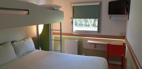 a bedroom with a bunk bed and a window at ibis budget Derby in Derby