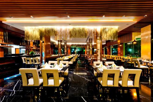 a dining room with white tables and white chairs at Royal Princess Larn Luang - SHA Extra Plus in Bangkok