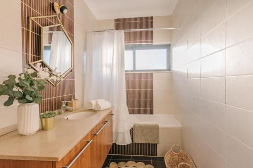 uma casa de banho com um lavatório e um espelho em Casas de Mar - Barra Mar em Olhão