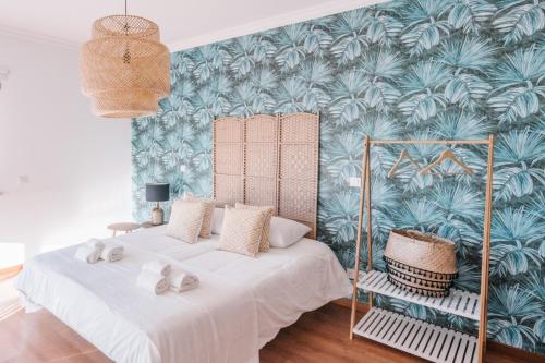 Duas camas num quarto com papel de parede tropical em Casas de Mar - Barra Mar em Olhão