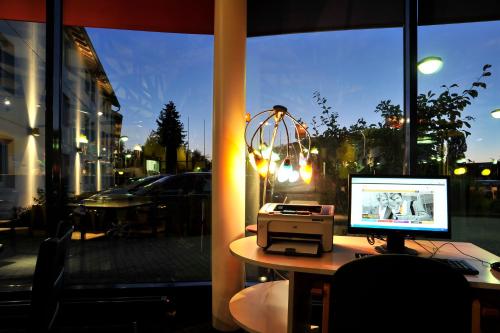 a computer sitting on a desk in front of a window at Plaza Inn Berlin Süd Ludwigsfelde in Ludwigsfelde