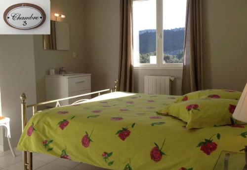 Un dormitorio con una cama con una colcha verde con fresas encima. en Au Petit Paradis, en Roquefort-la-Bédoule
