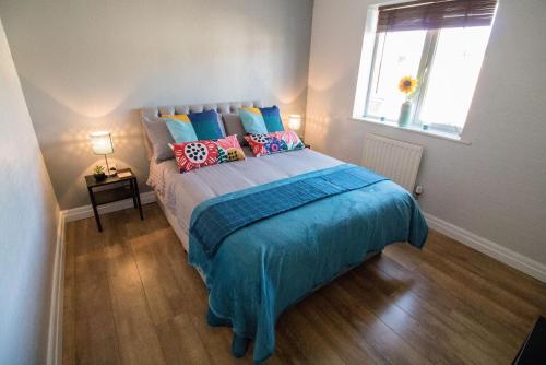 a bedroom with a bed with pillows and a window at Ideal Lodgings in Bury - Fairfield in Bury