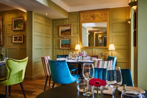 a dining room with a table and blue chairs at County Hotel in Chelmsford