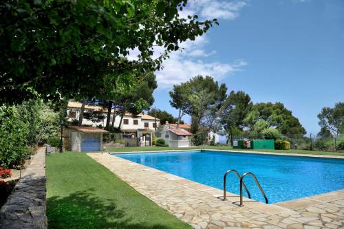 a swimming pool in a yard next to a house at Casa blanca de Begur con vistas al mar y piscina in Begur