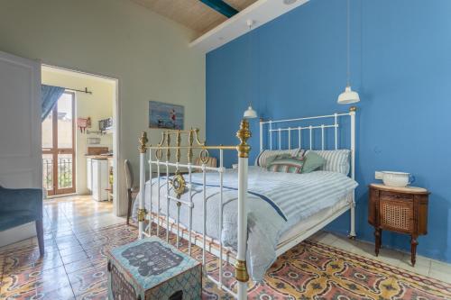 - une chambre avec un lit et un mur bleu dans l'établissement Maleth Inn, à Rabat