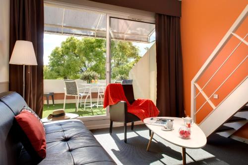 a living room with a couch and a table and a window at Royal Cottage in Cassis