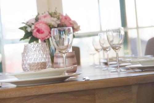 a table with wine glasses and a vase of flowers at 'Op de Borgt' met Finse Grill Kota in Wellen