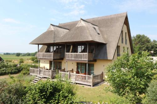 a large house with a thatched roof at Fewos Herrmann Achterwasserblick in Loddin