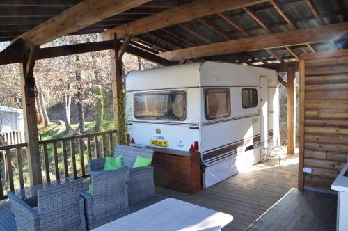 an rv parked on a deck with chairs at Camping du Moulin de Thoard in Thoard