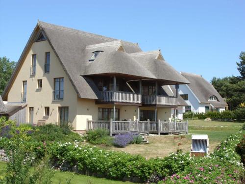 a large house with a thatched roof at Fewos Herrmann Achterwasserblick in Loddin