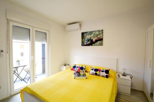 sypialnia z dużym żółtym łóżkiem w pokoju w obiekcie La Piazza w mieście Umag
