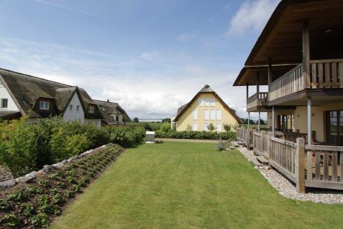 un patio trasero de una casa con un patio en Fewos Herrmann Achterwasserblick, en Loddin