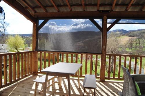 a table on a deck with a view of the mountains at Camping du Moulin de Thoard in Thoard