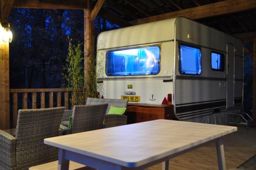 an rv with a table in front of it at Camping du Moulin de Thoard in Thoard