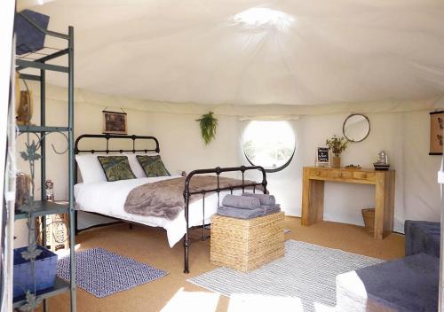 1 dormitorio con 1 cama en una tienda de campaña en Yurt at Le Ranch Camping et Glamping, en Madranges