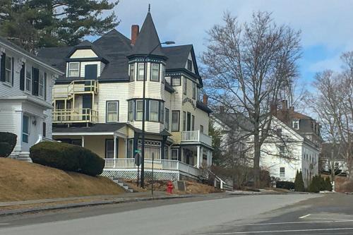 a large white house with a black roof on a street at 36 Main Apartments in Castine