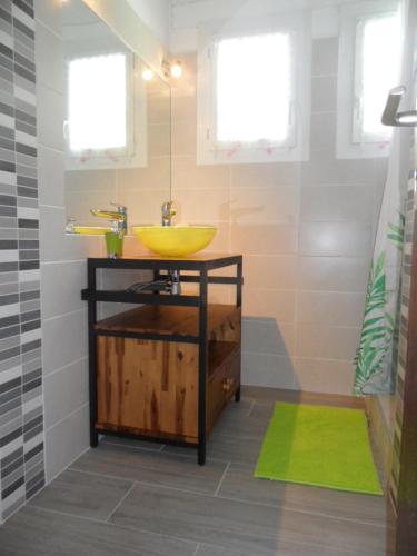 uma casa de banho com um lavatório amarelo e um lavatório amarelo em B&B La Viderente em Saussignac
