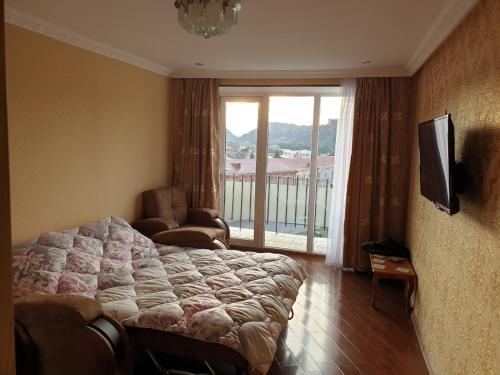 una camera da letto con un letto e una grande finestra di Сергей Сергеевич a Akhaltsikhe