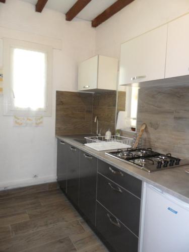 a kitchen with a sink and a stove top oven at B&B La Viderente in Saussignac