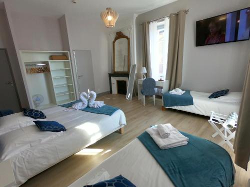 a room with two beds and a table with a mirror at Le Home in Belvès
