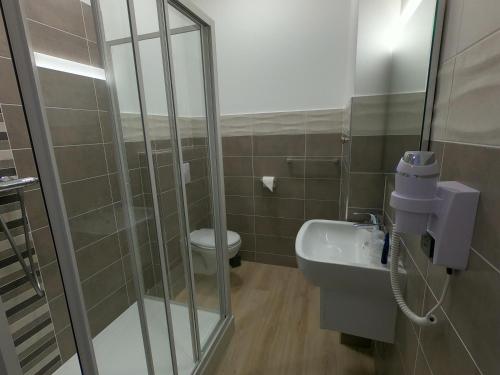 a bathroom with a shower and a toilet and a sink at Le Home in Belvès