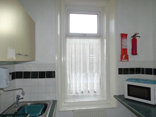 a window in a kitchen with a sink and a microwave at Beeton Villas Holiday Apartments in Blackpool