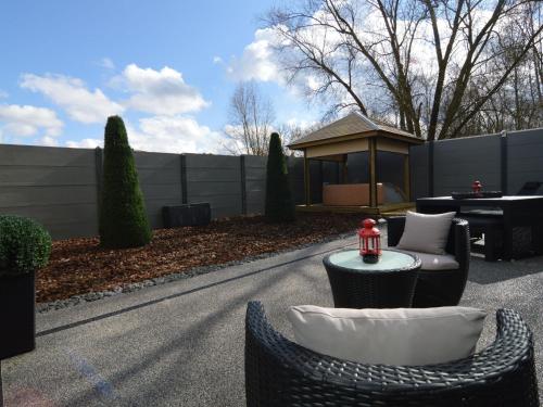 a patio with chairs and a table and a gazebo at Home in Welkenraedt with Jacuzzi Steam Shower in Welkenraedt