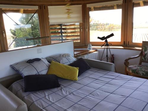 une chambre avec un grand lit avec deux oreillers dessus dans l'établissement Le Moulin de Margaux, à Margaux