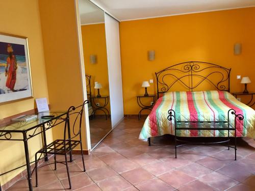 a bedroom with a bed and a glass table at Hotel Du Vignoble in Patrimonio