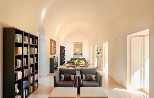 a living room with a couch and chairs and bookshelves at Villa Paola in Tropea