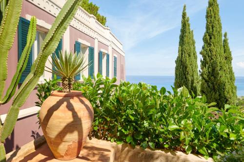a large vase sitting in front of a house with plants at Villa Paola in Tropea