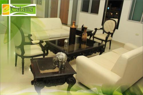 a living room with white furniture and a coffee table at Hotel Catama Inn in Fusagasuga