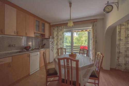 uma cozinha com mesa e cadeiras e uma janela em Къща за гости Вила Теkето I Family Guest House Villa Teketo em Nikolovo