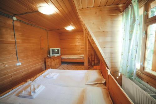 a small room with a bed in a wooden cabin at Karpatski Polonyny in Urych