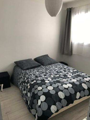 une chambre avec un lit avec une couette noire et blanche dans l'établissement COUCHANT RADIEUX Appartement 2 pièces 4 personnes vue mer, à Saint-Jean-de-Monts