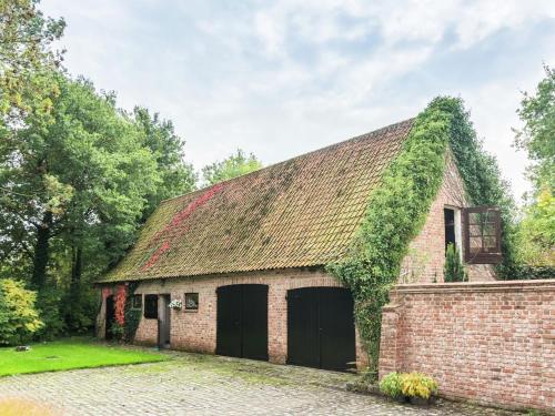 un viejo edificio de ladrillo con hiedra creciendo en él en This accommodation is full of atmosphere and on a beautiful estate en Zedelgem
