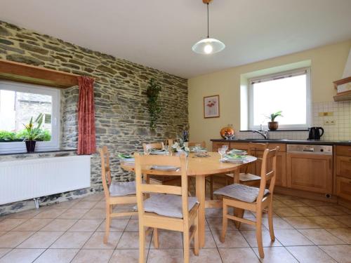 胡法利茲的住宿－Comfortable Cottage in Neufmoulin with Meadow View，厨房以及带木桌和椅子的用餐室。