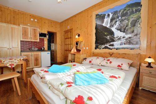 a bedroom with a large bed with a waterfall painting on the wall at Wesoła Chatka - Krupówki 37a -CENTRUM in Zakopane