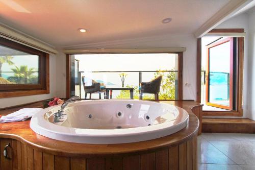 une grande baignoire dans une chambre avec balcon dans l'établissement george's boutique hotel, à Fethiye