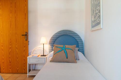 sypialnia z łóżkiem z niebieskim zagłówkiem w obiekcie Apartamento Porto Cari 21 w mieście Cala d´Or