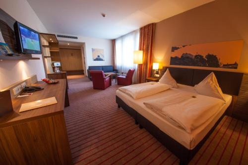 a hotel room with a bed and a television at Novina Hotel Tillypark in Nürnberg