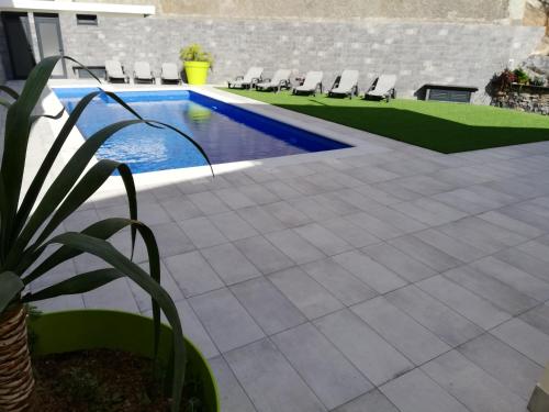a patio with chairs and a swimming pool at Imaculado Village in Funchal