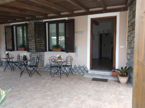 a patio with chairs and tables on a house at B&B LE ISOLE in San Teodoro