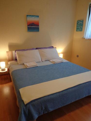 a bedroom with a large bed with two towels on it at Guesthouse Aotearoa Premantura in Premantura