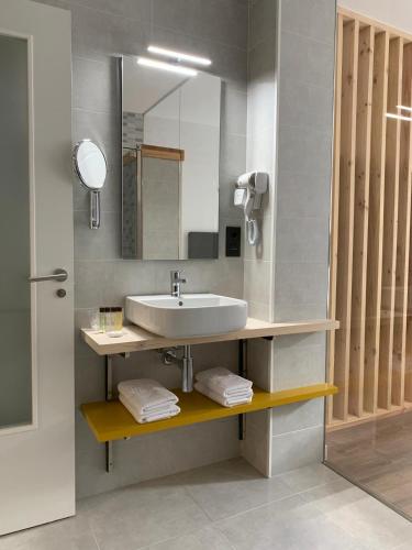 a bathroom with a sink and a mirror at Galerías 16 Viviendas Turísticas in Lugo