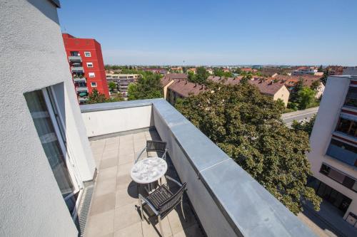 a balcony with two chairs and a table on a building at Novina Hotel Tillypark in Nürnberg