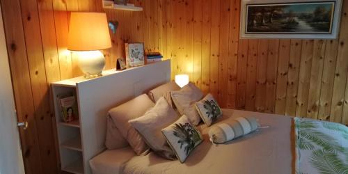 um quarto com uma cama branca com almofadas em "Le Sorelle" Apartments em Ferden