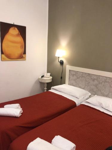 a hotel room with two beds and a telephone at Hotel Europeo Napoli in Naples